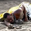 A migrant rests on the sand after arriving in a fiber boat at Las Burras beach in San Agustin, on the island of Gran Canaria, Spain, July 19, 2024. REUTERS - Borja Suarez .jpg